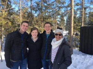 Four people posing in the snow